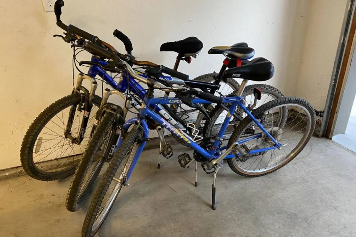 This image shows three bicycles neatly arranged against the garage wall, with an open floor space that suggests easy access to adventure gear. The setting is bright and organized, emphasizing the readiness for outdoor activities.